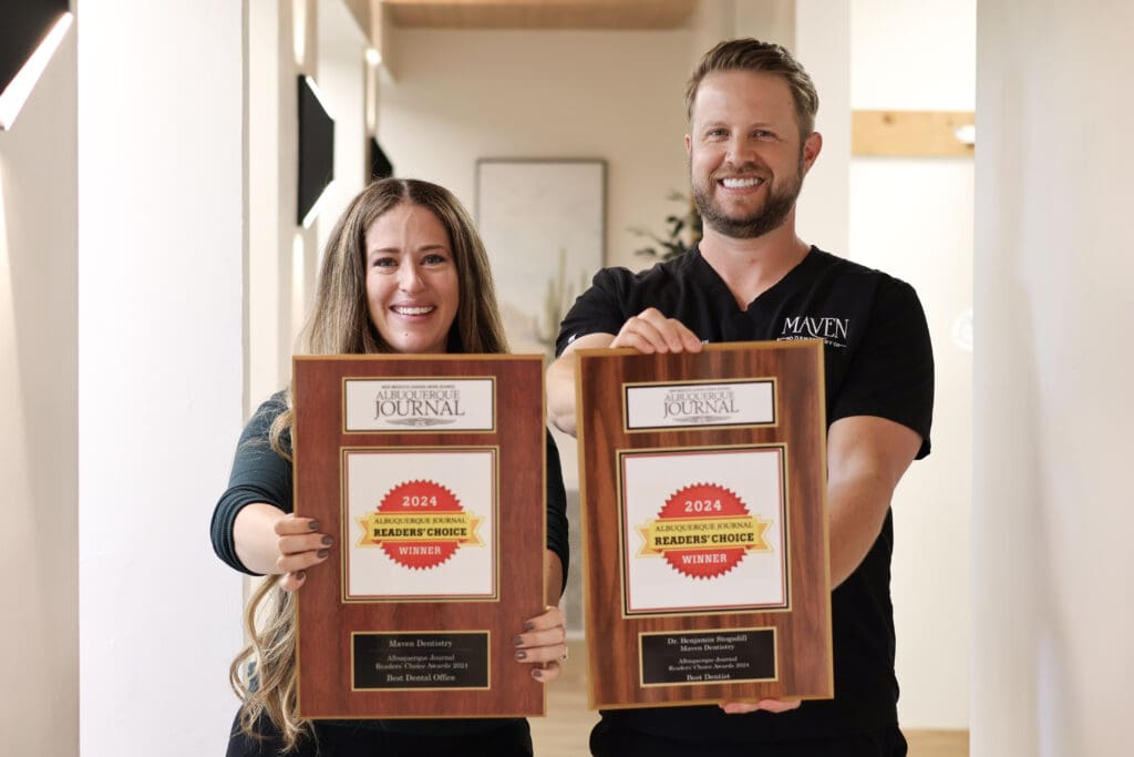 Dr. Stogsdill local dental office in Albuquerque holding Best Dentist in Albuquerque award frames