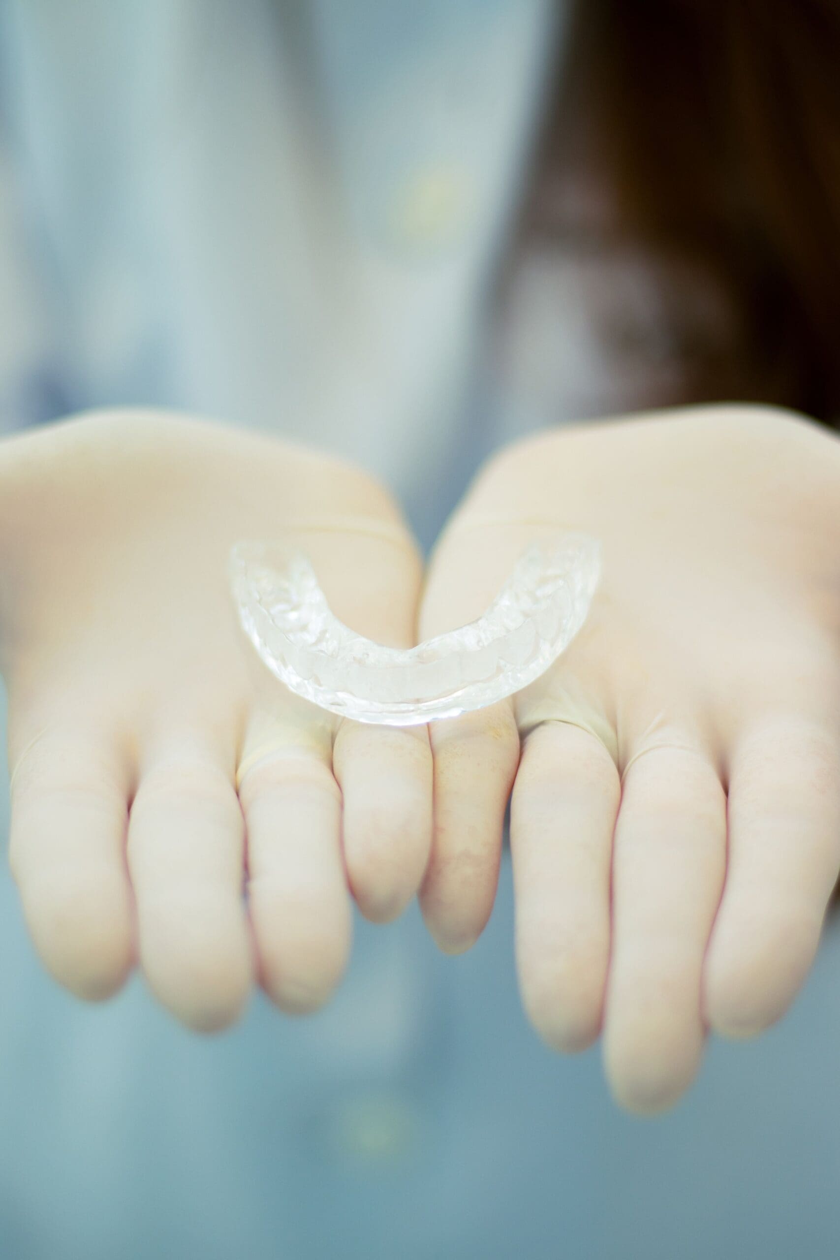Dentist holding a custom TMJ May Splint in her hands.